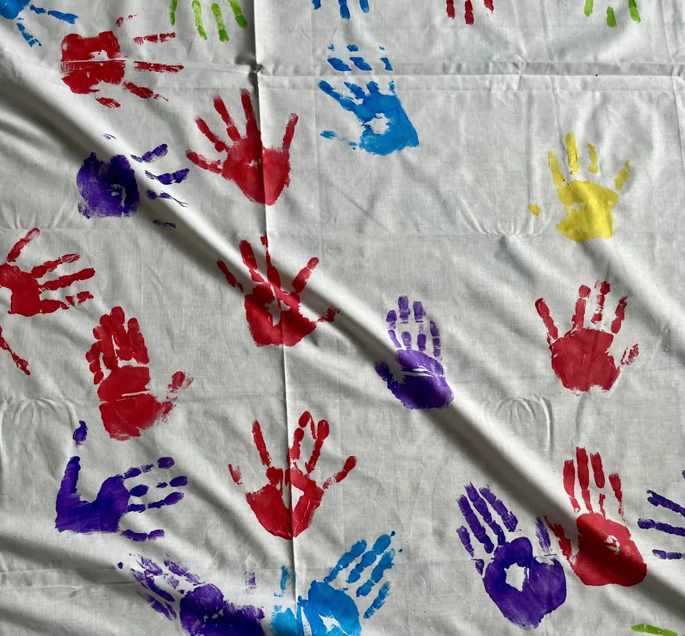 Bunte Handabdrücke auf einem Tuch